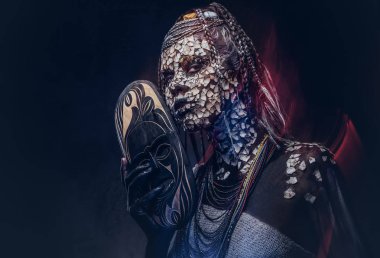 Yakın çekim bir Afrika şaman erkek geleneksel kostüm giyen Yerli Afrikalı kabile portresi. Kalıcı makyaj kavramı. Karanlık bir arka plan üzerinde izole.