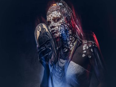 Yakın çekim bir Afrika şaman erkek geleneksel kostüm giyen Yerli Afrikalı kabile portresi. Kalıcı makyaj kavramı. Karanlık bir arka plan üzerinde izole.