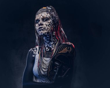 Yakın çekim bir cadıdan geleneksel kostüm giyen Yerli Afrikalı kabile portresi. Kalıcı makyaj kavramı. Karanlık bir arka plan üzerinde izole.