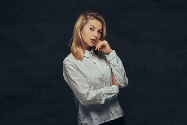 Portrait of a sensual blonde girl dressed in a white shirt, posing in a studio. — Stock Photo, Image