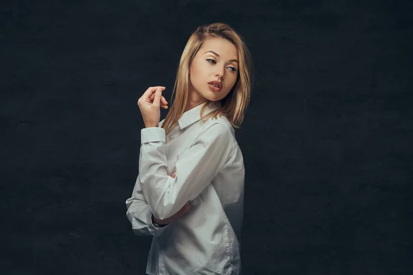 Portret van een sensuele blond meisje gekleed in een wit overhemd, poseren in een studio. — Stockfoto