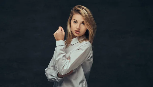 Portret van een sensuele blond meisje gekleed in een wit overhemd, poseren in een studio. — Stockfoto