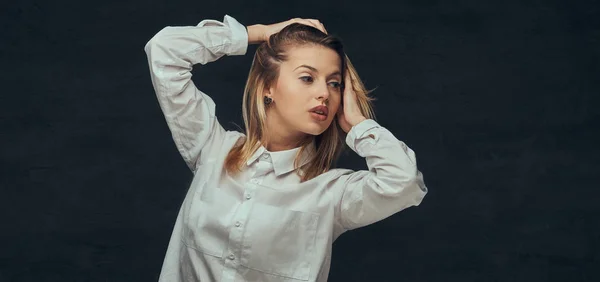 Portret van een sensuele blond meisje gekleed in een wit overhemd, poseren in een studio. — Stockfoto