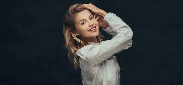 Portrait of a sensual blonde girl dressed in a white shirt, posing in a studio. — Stock Photo, Image