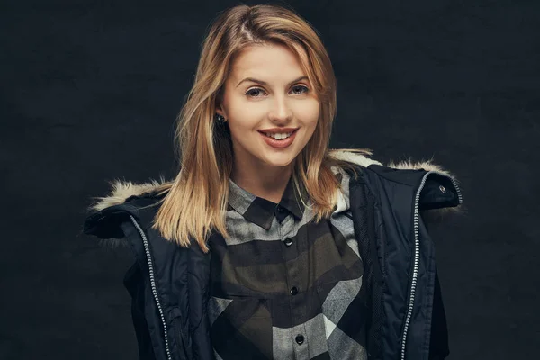 Retrato de una chica rubia sexy con chaqueta de invierno y camisa polar, de pie en un estudio . —  Fotos de Stock