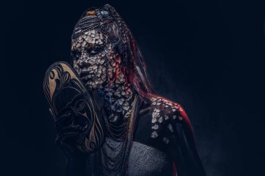 Yakın çekim bir cadıdan geleneksel kostüm giyen Yerli Afrikalı kabile portresi. Kalıcı makyaj kavramı. Karanlık bir arka plan üzerinde izole.