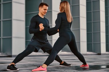 Modern kentin bir gökdelen karşı genç fitness iki ciddi hazırlarken germe yapıyor bir spor giyim sonra egzersiz.