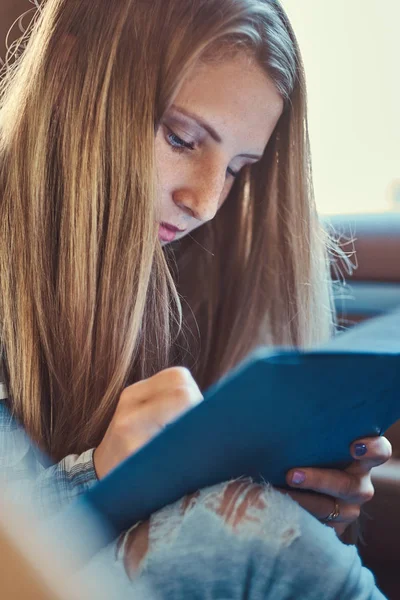 Porträt eines charmanten Mädchens, das in einem Notizblock Notizen macht und im Auto sitzt. — Stockfoto