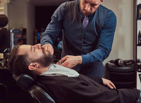 Barba de modelagem de cabeleireiro profissional com tesoura e pente na barbearia . — Fotografia de Stock