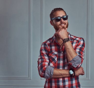 Beyaz bir duvar karşı bir stüdyoda poz bir gülümseyen şık Kızıl saçlı yakışıklı bir pazen gömlek ve güneş gözlüğü,.