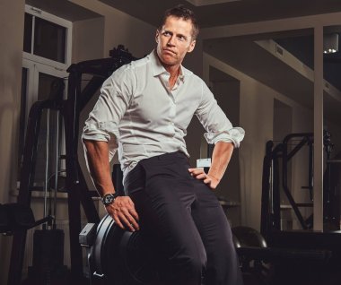 Resmi kıyafetler geldi zor gün işten sonra eğitim için spor salonuna bir yakışıklı emin işadamı.