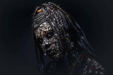 Korkunç bir Afrika şaman taşlaşmış ile kadın portresi cilt ve dreadlocks karanlık bir arka plan üzerinde kırık. Kalıcı makyaj kavramı.