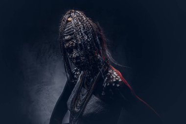 Yakın çekim bir cadıdan geleneksel kostüm giyen Yerli Afrikalı kabile portresi. Kalıcı makyaj kavramı. Karanlık bir arka plan üzerinde izole.