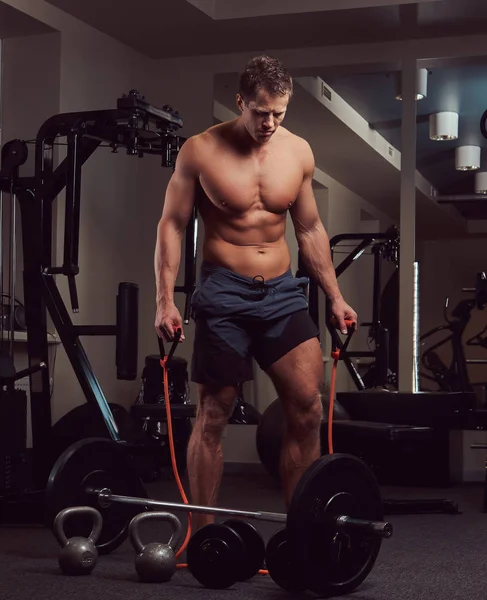 Ein Muskulöser Sportler Ohne Hemd Der Fitnessstudio Mit Einem Expander — Stockfoto