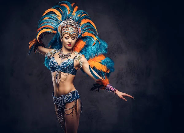 Studio portret van een sexy vrouw in een kleurrijke weelderige carnaval feather passen. Geïsoleerd op een donkere achtergrond. — Stockfoto