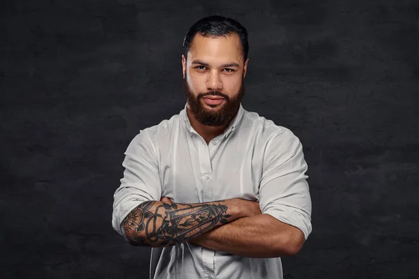 Retrato de um homem tatuado afro-americano bonito com cabelo e barba elegantes, fica com os braços cruzados . — Fotografia de Stock