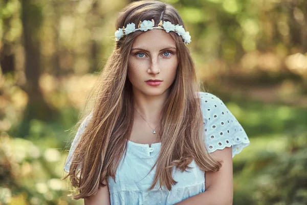 白いドレスと白い花輪緑秋の森ヘッド ポーズで魅力的な美しい女性 — ストック写真