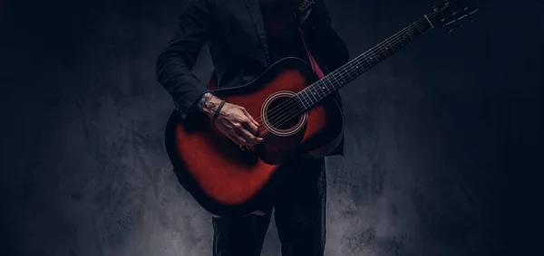 Περικομμένη εικόνα του μουσικός σε κομψά ρούχα με μια κιθάρα στα χέρια του, παίζει και θέτοντας. — Φωτογραφία Αρχείου