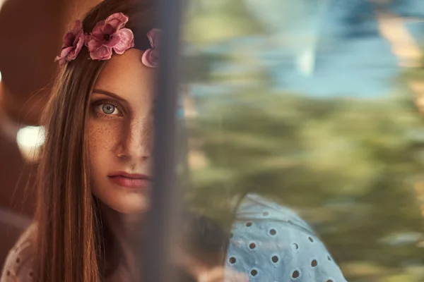 Porträt einer schönen Frau in weißem Kleid und weißem Kranz auf dem Kopf, die im Auto auf dem Rücksitz sitzt. — Stockfoto