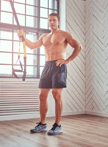 Shirtless svalnatý muž dělá cvičení s Trx. — Stock fotografie