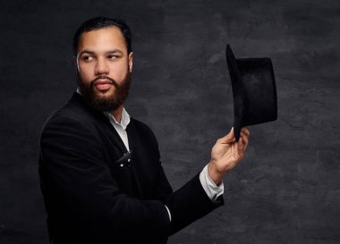 Zarif bir takım, Afrikalı-Amerikalı adam tutar siyah bir şapka.