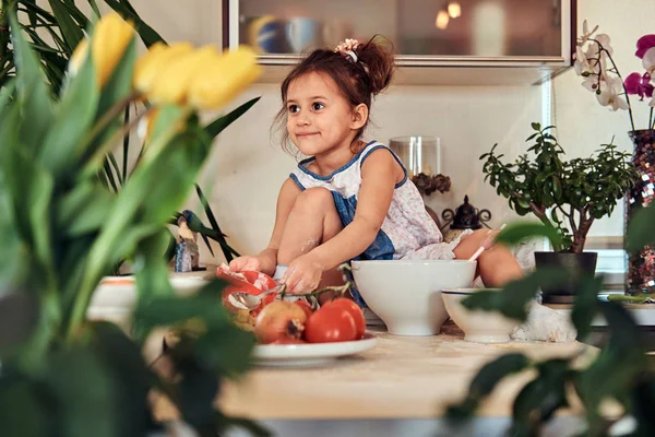 Dulce niña linda aprende a cocinar una comida en la cocina . —  Fotos de Stock