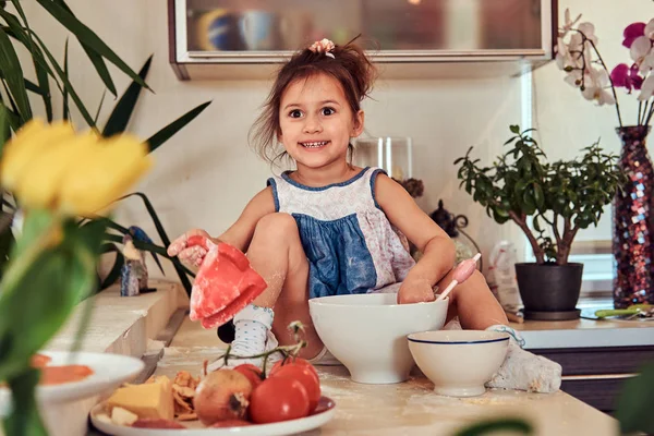 Dulce niña linda aprende a cocinar una comida en la cocina . —  Fotos de Stock