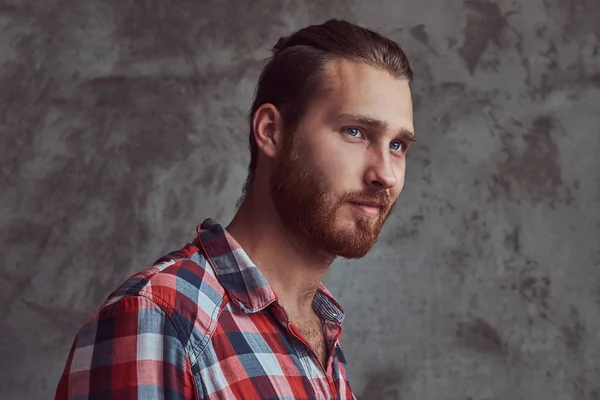 Jovem bonito ruiva modelo homem em uma camisa de flanela em um fundo cinza . — Fotografia de Stock