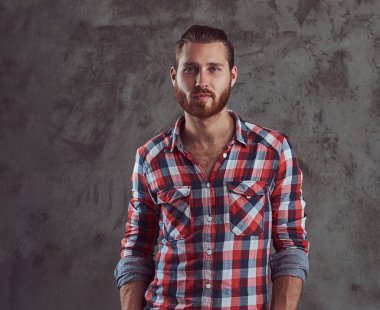 Genç yakışıklı Kızıl saçlı model adam gri bir arka plan üzerinde flanel gömlekli.