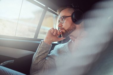 Bir gri takım elbise ve pembe gömlek, başarılı şık genç işadamı bir arka koltukta bir lüks Araba sürme.