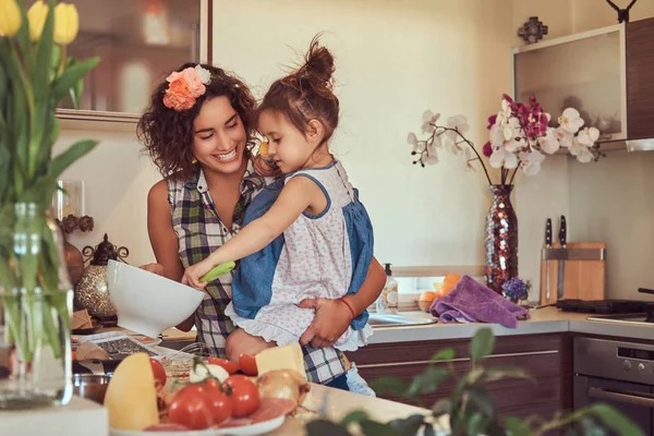 Gyönyörű spanyol anya tanítja a aranyos kis lánya készítsen pizza a konyhában. — Stock Fotó