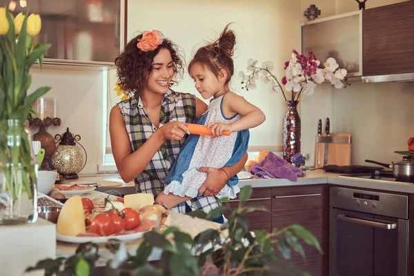 Hermosa madre hispana enseña a su linda hijita a preparar pizza en la cocina . —  Fotos de Stock