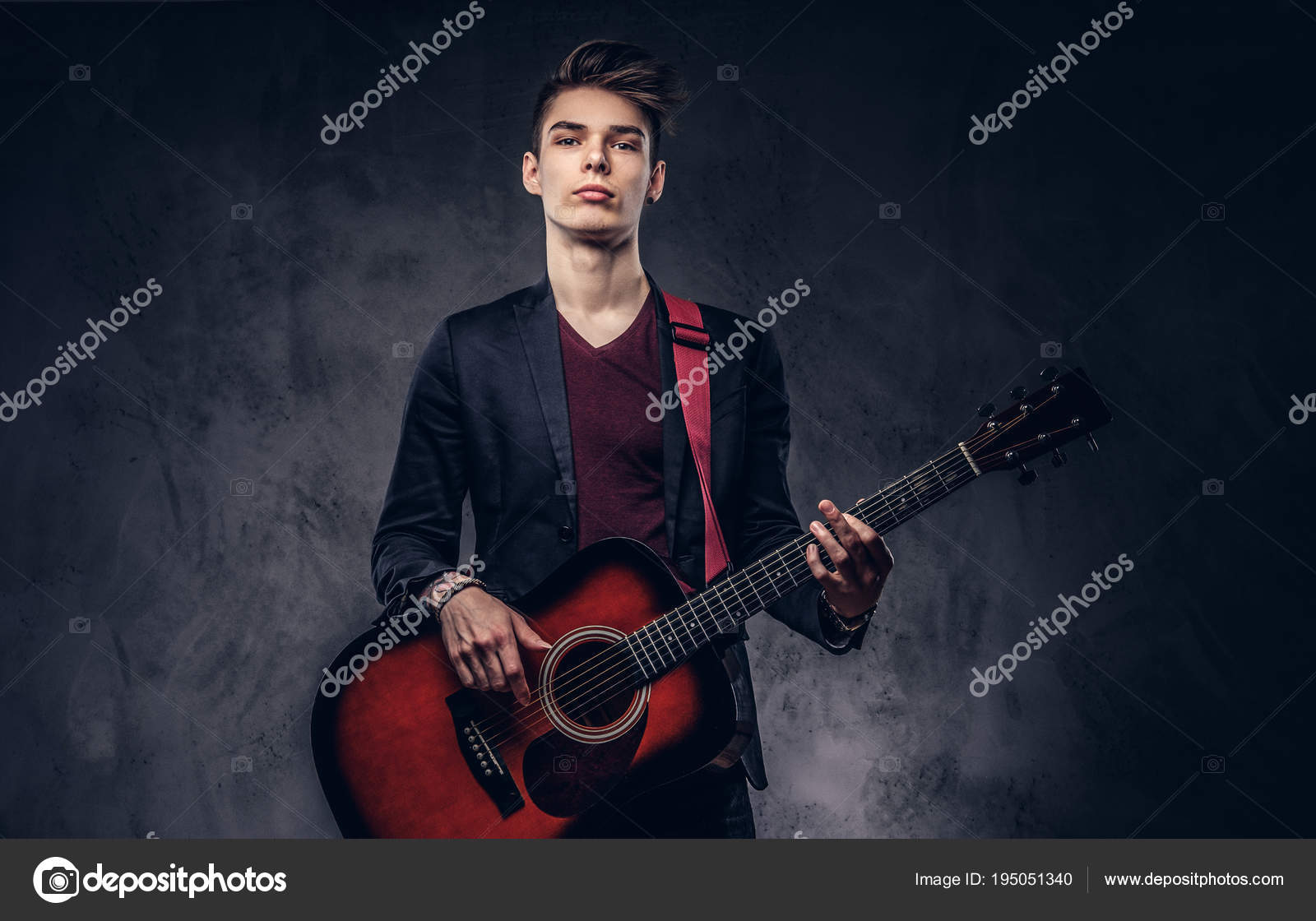 Stylish young musician with stylish hair in elegant clothes, playing on an  acoustic guitar. Stock Photo by ©fxquadro 195051340