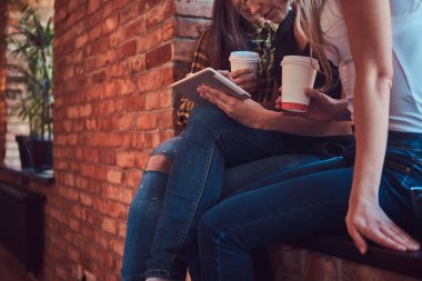 İn kadın arkadaş grubu ile rahat kıyafetler tartışırken süre seyir bir şey bir odada dijital tablet ile çatı iç.