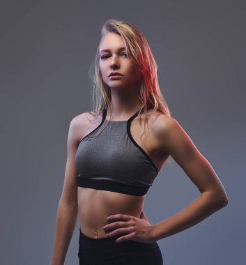 Bir stüdyoda poz bir spor giyim seksi ince sarışın kız.