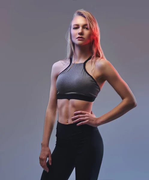 Sexy ragazza bionda sottile in uno sportswear posa in uno studio . — Foto Stock