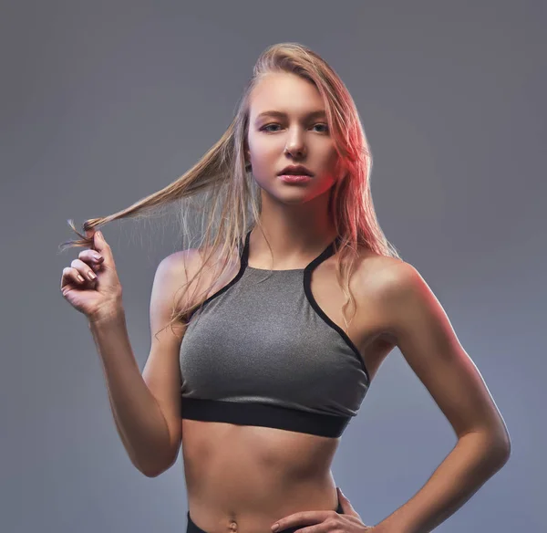 Sexy štíhlá blondýnka v sportovní pózuje ve studiu. — Stock fotografie