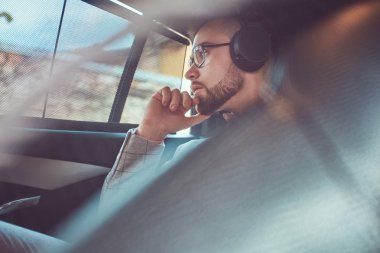 Bir gri takım elbise ve pembe gömlek, başarılı şık genç işadamı bir arka koltukta bir lüks Araba sürme.