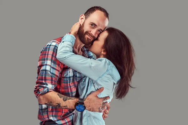 Atractiva pareja, hombre barbudo y chica morena abrazándose en un estudio . — Foto de Stock