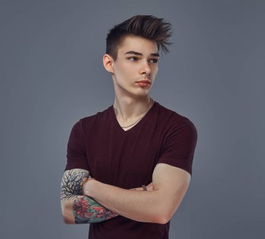 Yakışıklı şık genç şık saç ile adam ve bir stüdyoda poz kolundaki dövme.