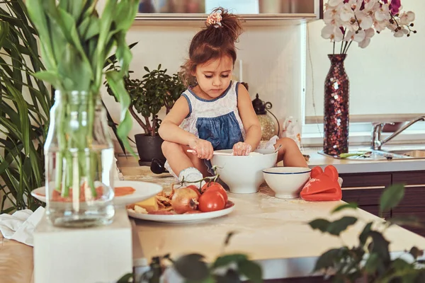 Dulce niña linda aprende a cocinar una comida en la cocina . —  Fotos de Stock