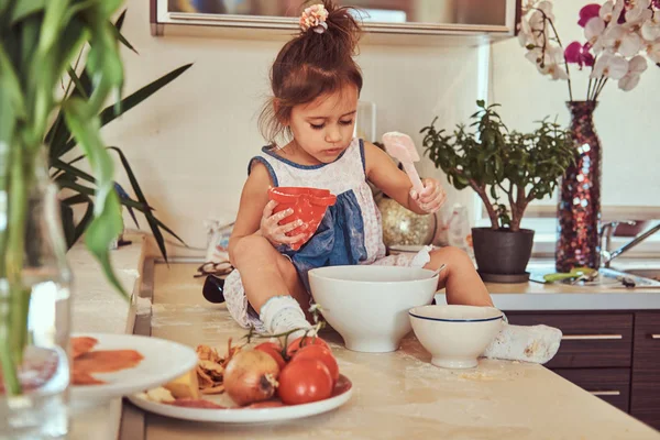 Édes kis aranyos lány megtanulja, hogy főzni étkezést a konyhában. — Stock Fotó