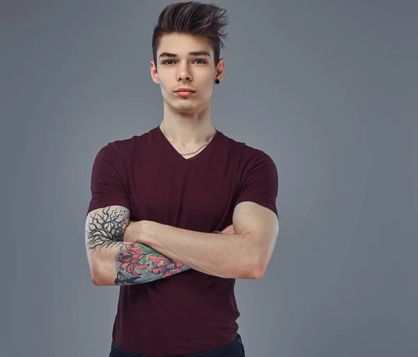 Stilig fashionabla ung kille med snygg hår och tatuering på armen poserar i en studio. — Stockfoto