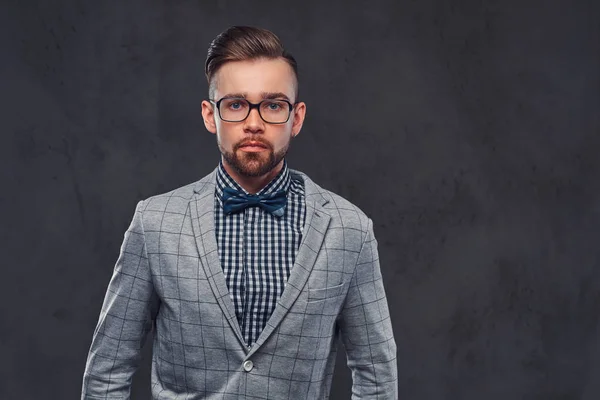 自信时尚的胡子男子与发型和眼镜在优雅的复古灰色西装和弓领带, 摆在演播室. — 图库照片