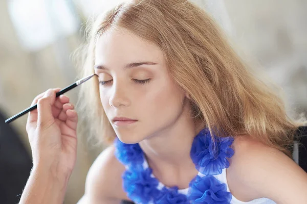 Estilista haciendo el maquillaje para una hermosa modelo de niña . —  Fotos de Stock