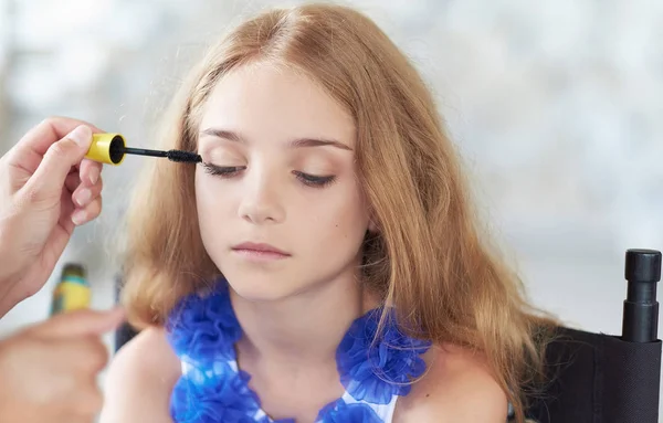 Estilista haciendo el maquillaje para una hermosa modelo de niña . —  Fotos de Stock