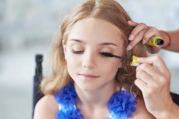 Estilista haciendo el maquillaje para una hermosa modelo de niña . —  Fotos de Stock