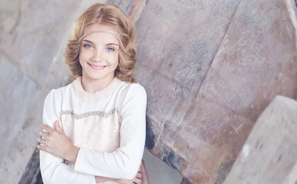 Happy little girl model with charming smile posing in a studio. — Stock Photo, Image