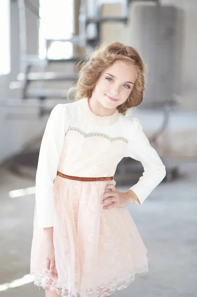 Happy little girl model with charming smile posing in a studio. — Stock Photo, Image