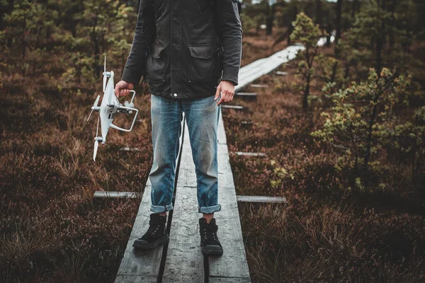 Jovem está andando no parque florestal com seu drone — Fotografia de Stock